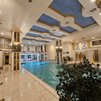 Home Acemoğlu Hamamı spa merkezi – süslemeli tavan ve geniş yüzme havuzuyla lüks dinlenme alanı.