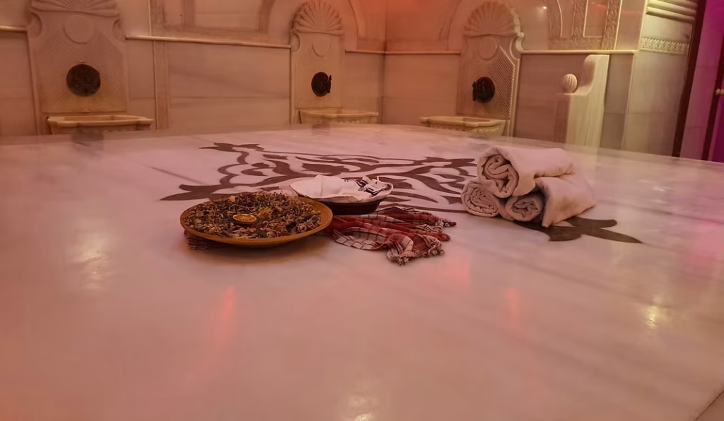 Tarihi Türk Hamamı Deneyimi – Acemoğlu Hamamı Acemoğlu Tarihi Hamam’da geleneksel göbek taşı üzerinde kese ve havlu ile hazırlanan Osmanlı tarzı hamam deneyimi.