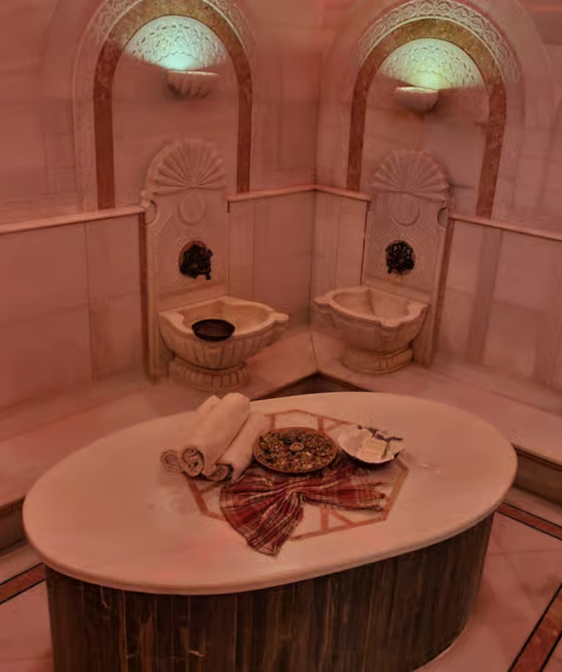 Our Services Mermer kurna ve geleneksel mimari detaylarla süslenmiş Osmanlı tarzı hamam iç mekanı – Acemoğlu Tarihi Hamam.